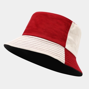 Detail of two-tone bucket hat showing red and beige stitching and thick canvas texture
