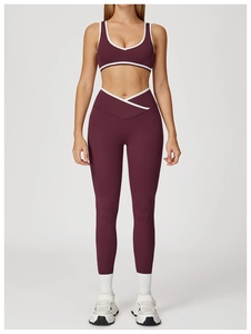 Detail of high-waisted yoga pants with white V-cross waistband and plum purple fabric