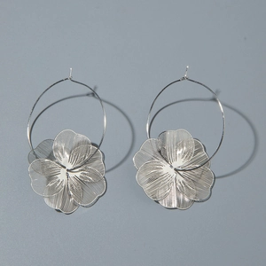 Vue détaillée des boucles d'oreilles fleuries argentées avec motif tissé métallique