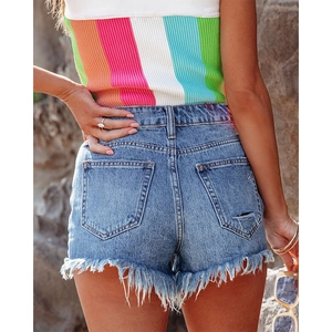 Outdoor back view of blue denim shorts with distressed frayed edges and rear pockets