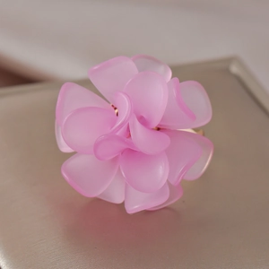 Macro view of handmade pink resin flower petal ring with soft light on metallic base