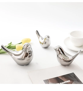 Set de tres pájaros de cerámica plateada galvanizada en una escena moderna y elegante