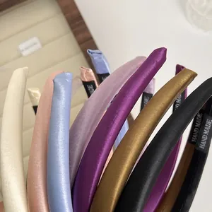 Glossy satin padded headbands in various colors featuring handmade woven labels