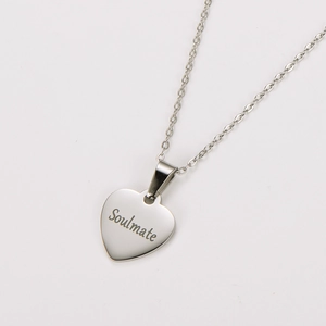 Macro shot of silver stainless steel heart pendant with Soulmate laser engraving