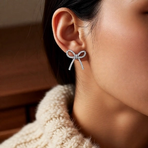 Close-up of sparkling cubic zirconia bow ear cuff on model showing detailed pave setting