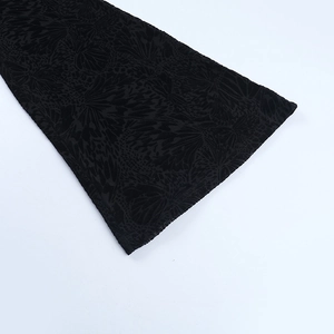 Detail of black flocking fabric with intricate butterfly jacquard pattern and texture