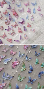 Macro detail of laser glitter butterfly nail art stickers with embossed gold texture
