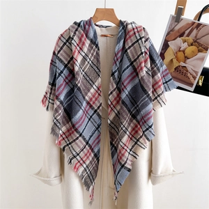 Detail of soft plaid scarf with fringe edge in beige, grey, red and blue tones