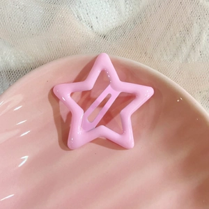Detail view of a pink star hair clip on a pink ceramic plate with white mesh