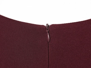 Detail view of the high-density knit fabric and invisible zipper on the burgundy dress