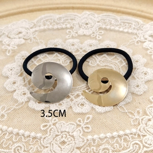 Detail view of 3.5cm spiral alloy hair ties in gold and silver finishes on lace