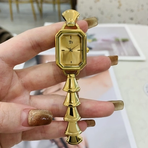 Dettaglio di un orologio al quarzo dorato ottagonale da donna con cinturino in metallo di lusso