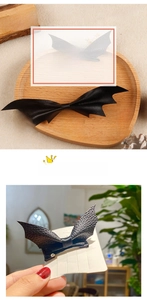 Detail of black bat wing hair clips showing leather texture and sturdy metal clip