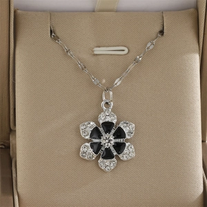 Collier à pendentif floral avec pétales en émail noir et cristaux sur une chaîne argentée