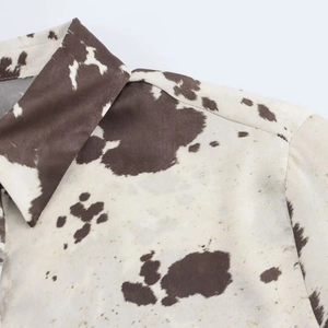 Détail du col de la chemise à imprimé vache marron et texture du tissu tissé