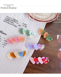 Detailed close-up of acetate heart hair clips with colorful marble textures and patterns