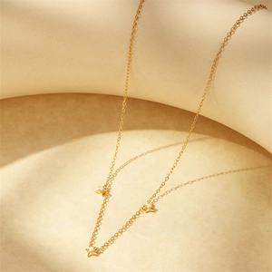 Detailed macro view of gold-plated silver chain necklace with three star pendants and opals