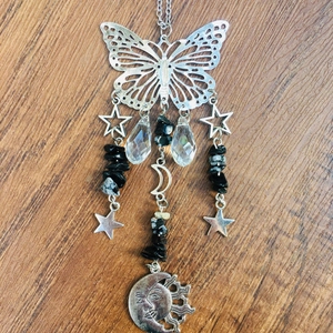 Detail of silver suncatcher with butterfly, moon, star motifs and faceted crystal drops