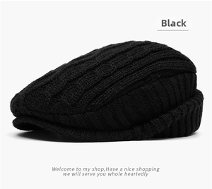 Detailed view of black cable knit pattern on a warm winter newsboy cap with short brim