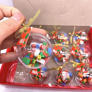 Close-up of Christmas transparent ball ornaments filled with mini erasers and gold hanging cords