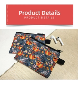 Detail view of tropical sloth pattern canvas coin pouches with black zipper on wood surface