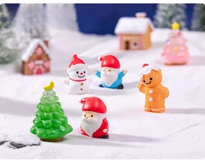 Miniature resin Christmas figurines including Santa, Snowman and tree on a snowy background