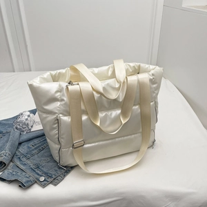 Close-up of the quilted cream fitness bag showing its glossy nylon texture and side zipper