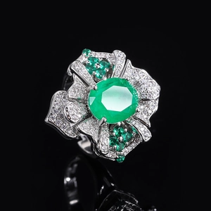 Vintage emerald ring with silver band and clear zircon accents on black background