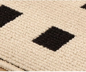 Macro shot of waterproof beige and black woven kitchen mat texture with tufted diamond patterns