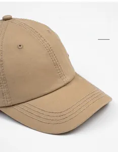 Close-up of khaki cotton baseball cap showing wide brim stitching and embroidered vents