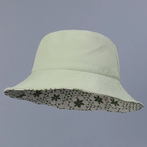 Détail d'un chapeau bob réversible vert menthe avec motif floral délicat sur le bord