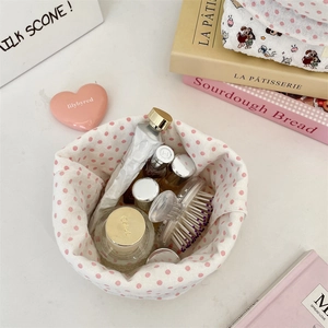 Close-up of quilted floral drawstring storage bag with perfume and cosmetics inside