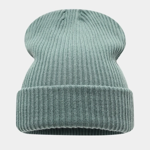 Gros plan du bonnet en tricot vert sauge montrant la texture côtelée détaillée