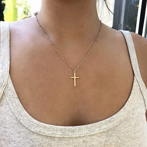 Detail shot of the 18K gold-plated stainless steel cross pendant and delicate chain link