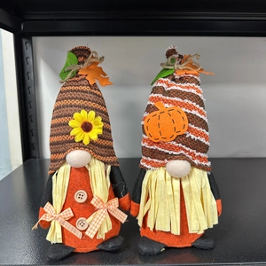 Detail of autumn harvest gnomes with knit hats, sunflower and pumpkin decor elements