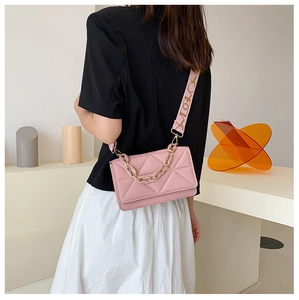 Detail view of pink quilted crossbody bag with stylish resin chain and wide strap