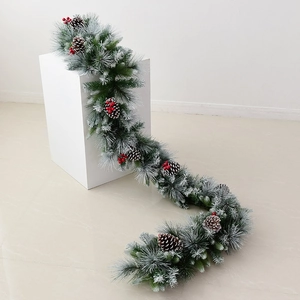 Artificial Christmas garland with frosted pine needles, cones and red berries for home decor