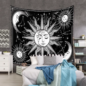 Detail of bohemian sun and moon tapestry hanging on a bedroom wall with stars and constellations