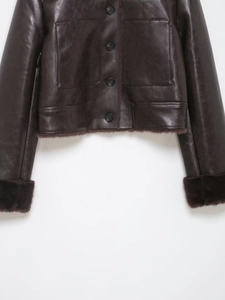 Detail of faux fur trim on the hem and cuffs of a dark brown vintage leather jacket