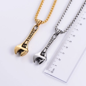 Detail of gold and silver wrench necklaces in 316L stainless steel with size ruler
