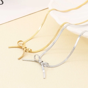Détail de colliers avec pendentif nœud en or et argent sur des chaînes de type serpent