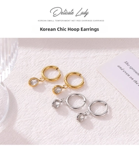 Detailed macro view of gold and silver hoop earrings with water drop zircon pendants