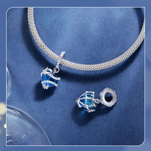 Macro dello charme a cuore in argento S925 con zircone blu su bracciale intrecciato