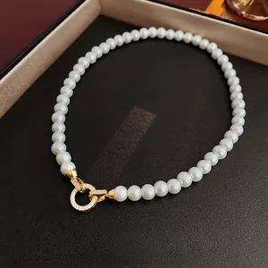 Gros plan du fermoir en or 18 carats avec zircones sur un collier de perles élégant