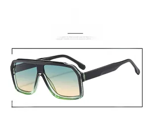 Detail of retro oversized sunglasses featuring black frames and blue-yellow gradient lenses