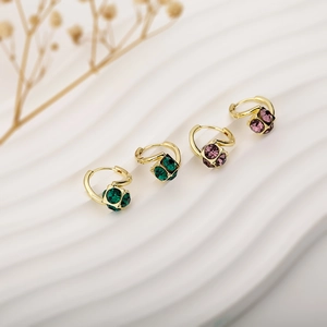 Luxury gold hoop earrings with green and purple crystal cubes on a white wave base