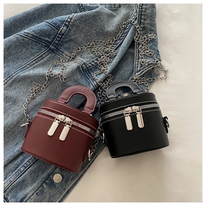 Sacs cylindriques vintage bicolores avec coutures blanches et chaînes argentées sur denim