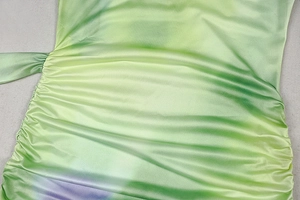 Close-up of ruched texture and gradient satin fabric on sleeveless cocktail dress