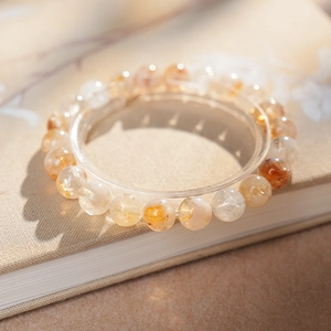 Macro d'un bracelet en perles de quartz citrine sur la surface d'un livre ancien de qualité