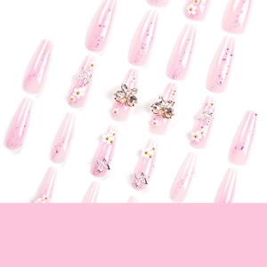 Pink press-on nails with 3D flowers, rhinestone butterflies, and purple glitter accents